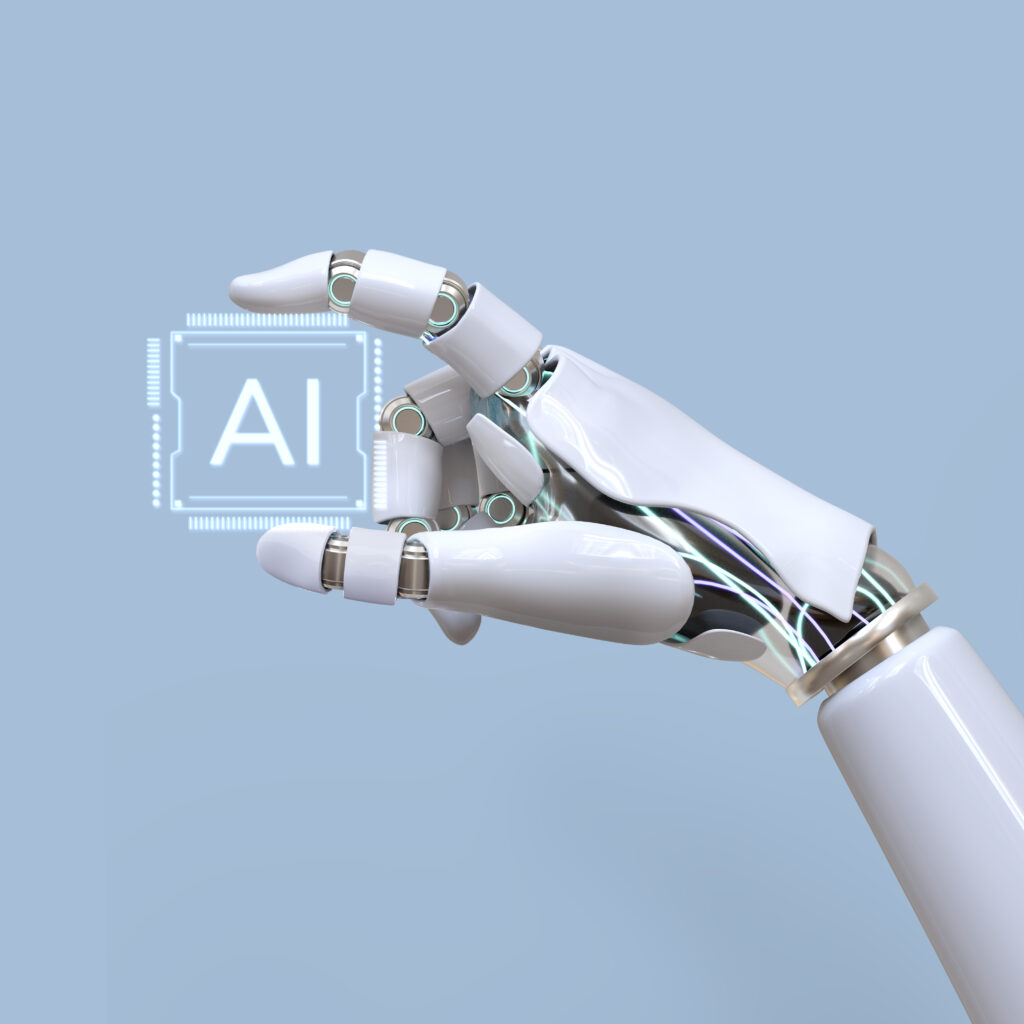 Das Bild zeigt eine Roboterhand auf blauem Hintergrund. Die Hand hält einen Computerchip mit der Aufschrift "AI".